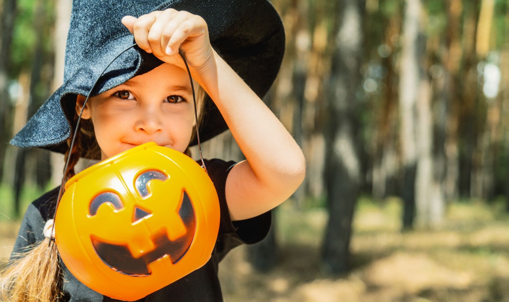 girl with jack-o-lantern bucket and witch hat