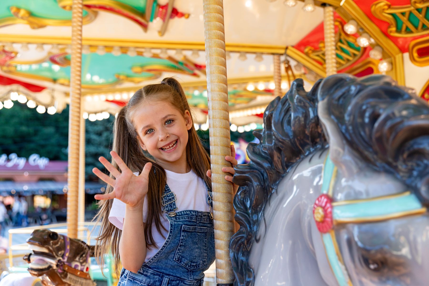 little girl riding horse of merry go round